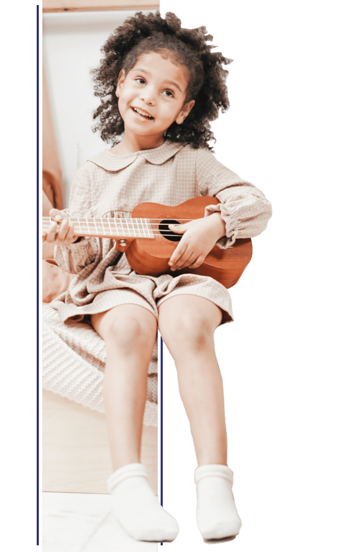 A young girl is playing the ukulele.