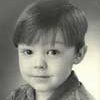 A young boy with short hair and wearing a shirt.