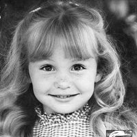 A young girl with long hair and a smile.